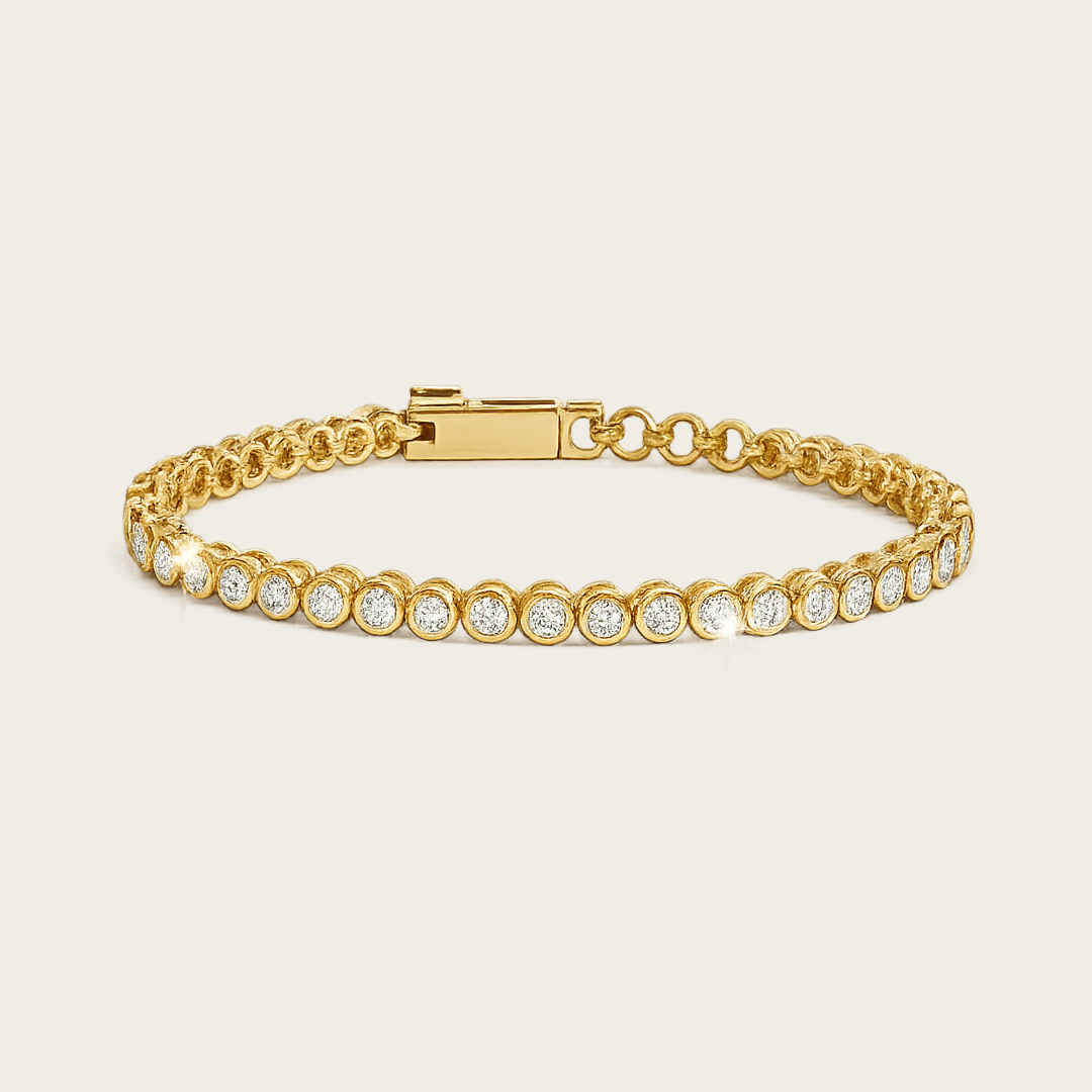 Minimalist Cubic Zirconia Gold Tennis Bracelet featuring a row of round-cut sparkling cubic zirconia stones set in a polished gold band, displayed on a soft off-white #F0EDE7 background in high-quality luxury jewelry style.