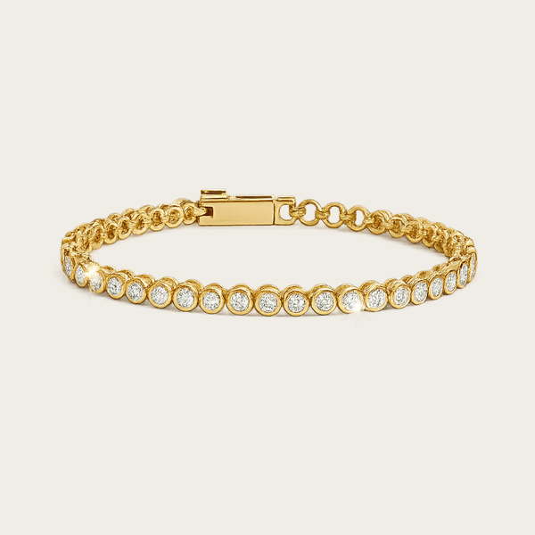Minimalist Cubic Zirconia Gold Tennis Bracelet featuring a row of round-cut sparkling cubic zirconia stones set in a polished gold band, displayed on a soft off-white #F0EDE7 background in high-quality luxury jewelry style.