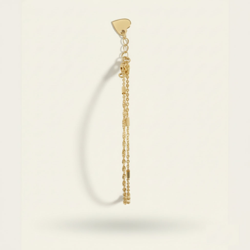 Minimalist double bracelet set in polished silver with adjustable heart clasp and dual chain design, displayed on a soft off-white #F0EDE7 background in high-quality luxury jewelry style.